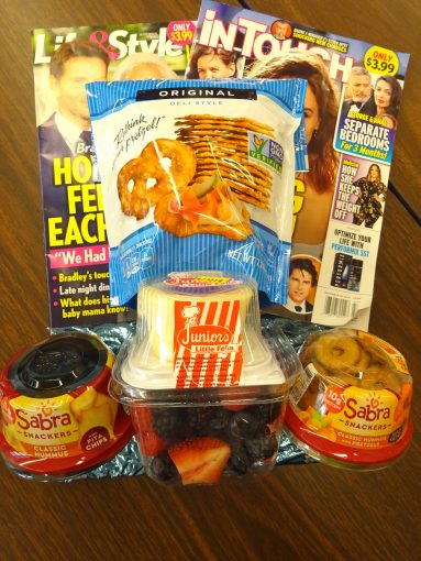 Magazines with snacks of fruit and pretzels in front