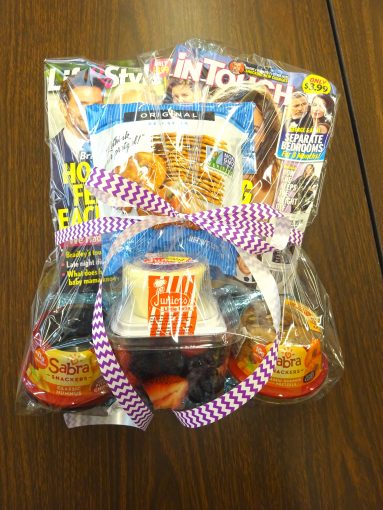 A plastic bag with a bow containing magazines and snacks